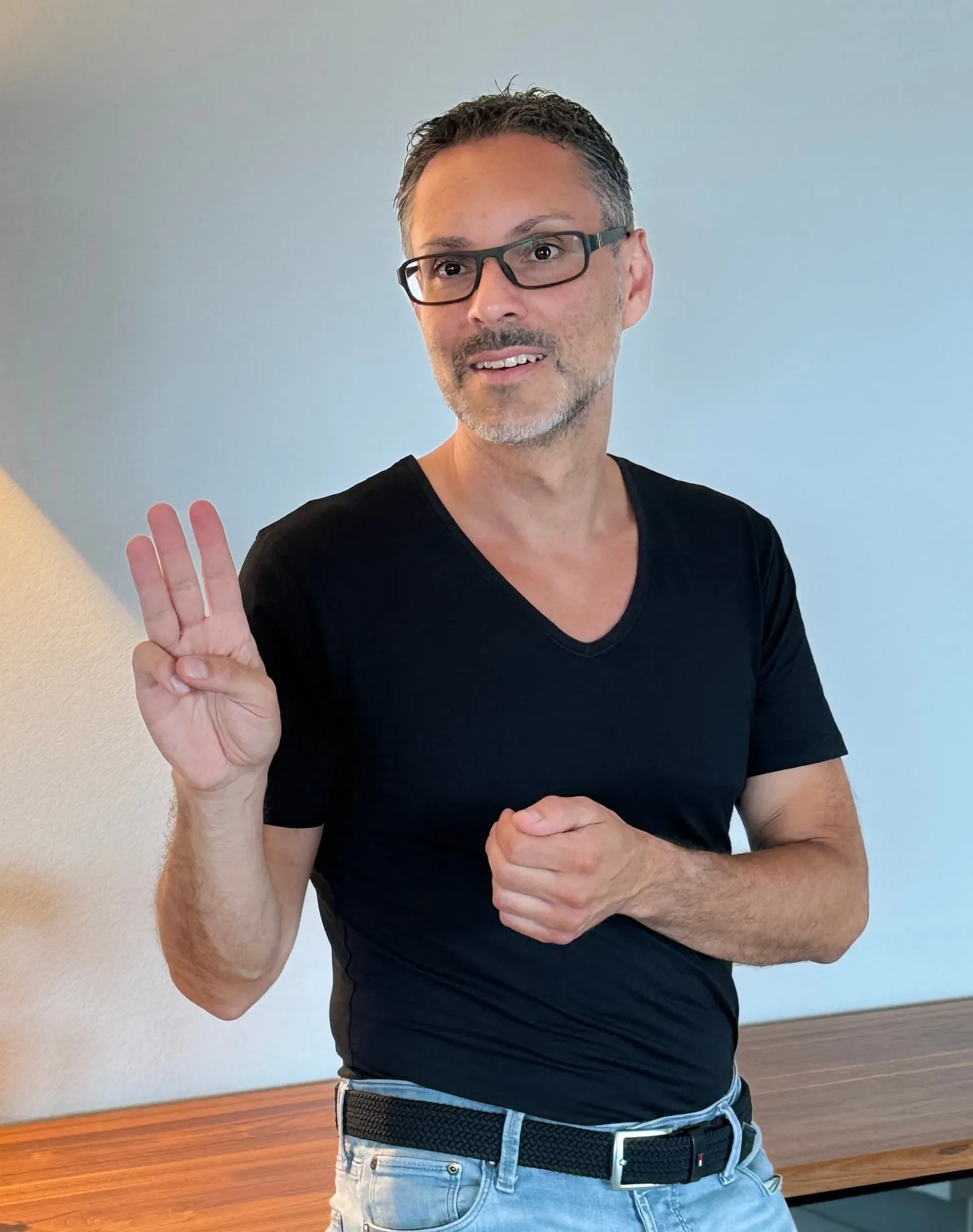 Patrick Schmid zeigt mit der Hand eine Drei